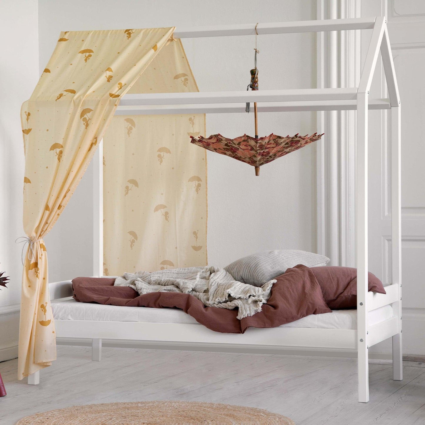house bed in white with textiles in a white room background